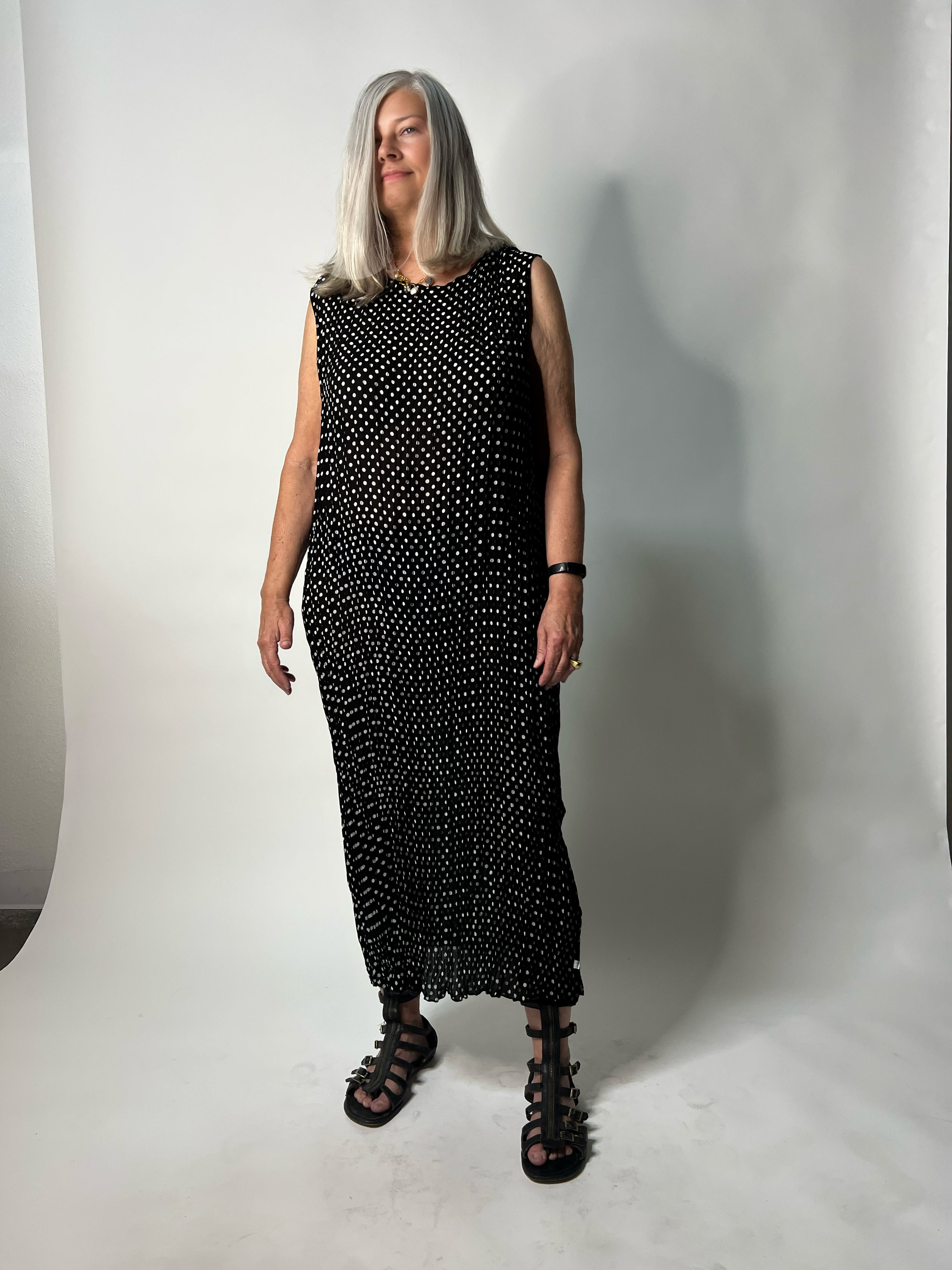 Woman wearing a black polka dot dress against a white background