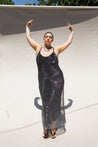 Plus size model with her arms up wearing the crystal stone mesh dress in hematite with our black cabaret slip.