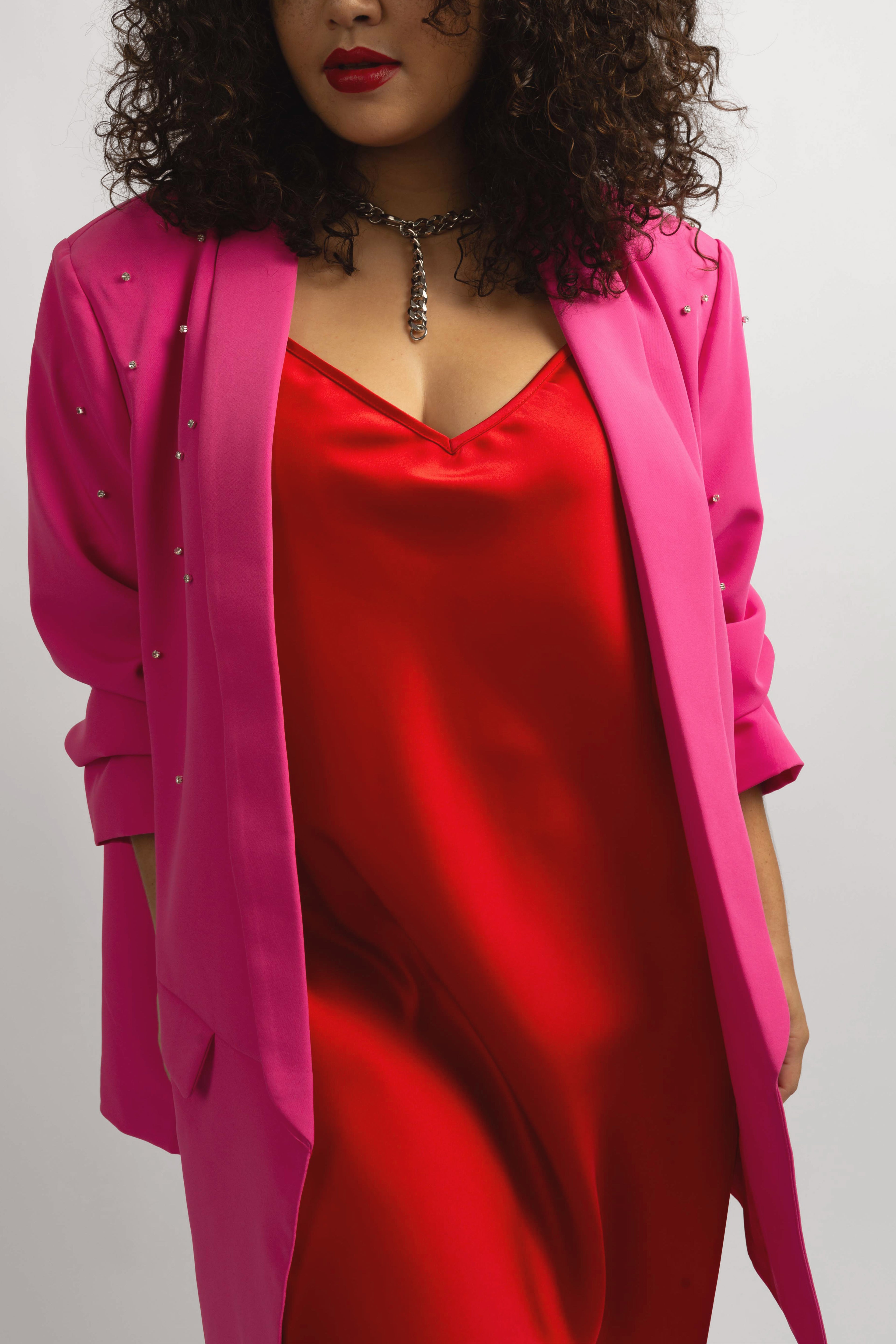 model wearing hot pink crystal blazer with red slip dress