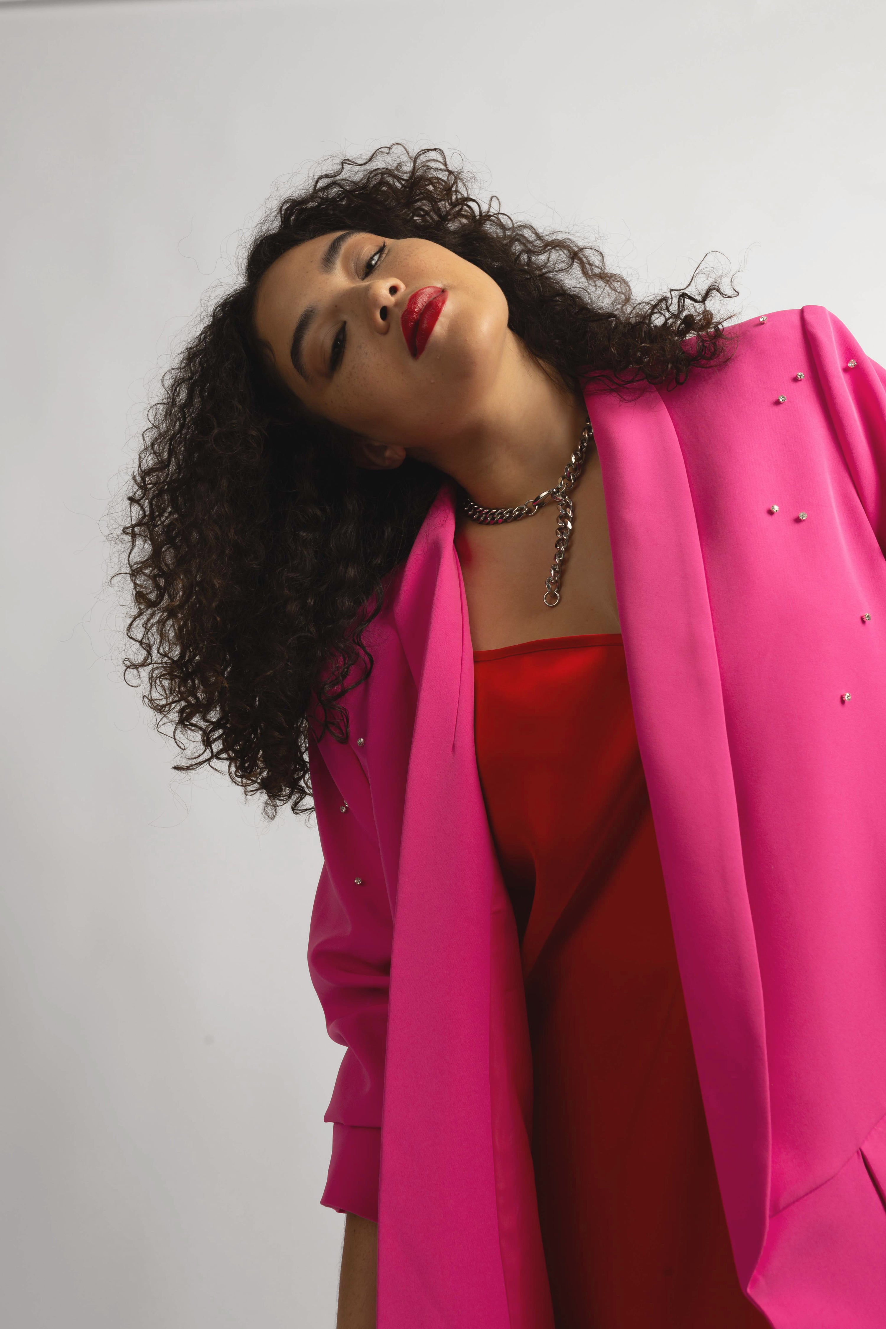 model wearing silver lariat with red slip and oversized pink crystal blazer