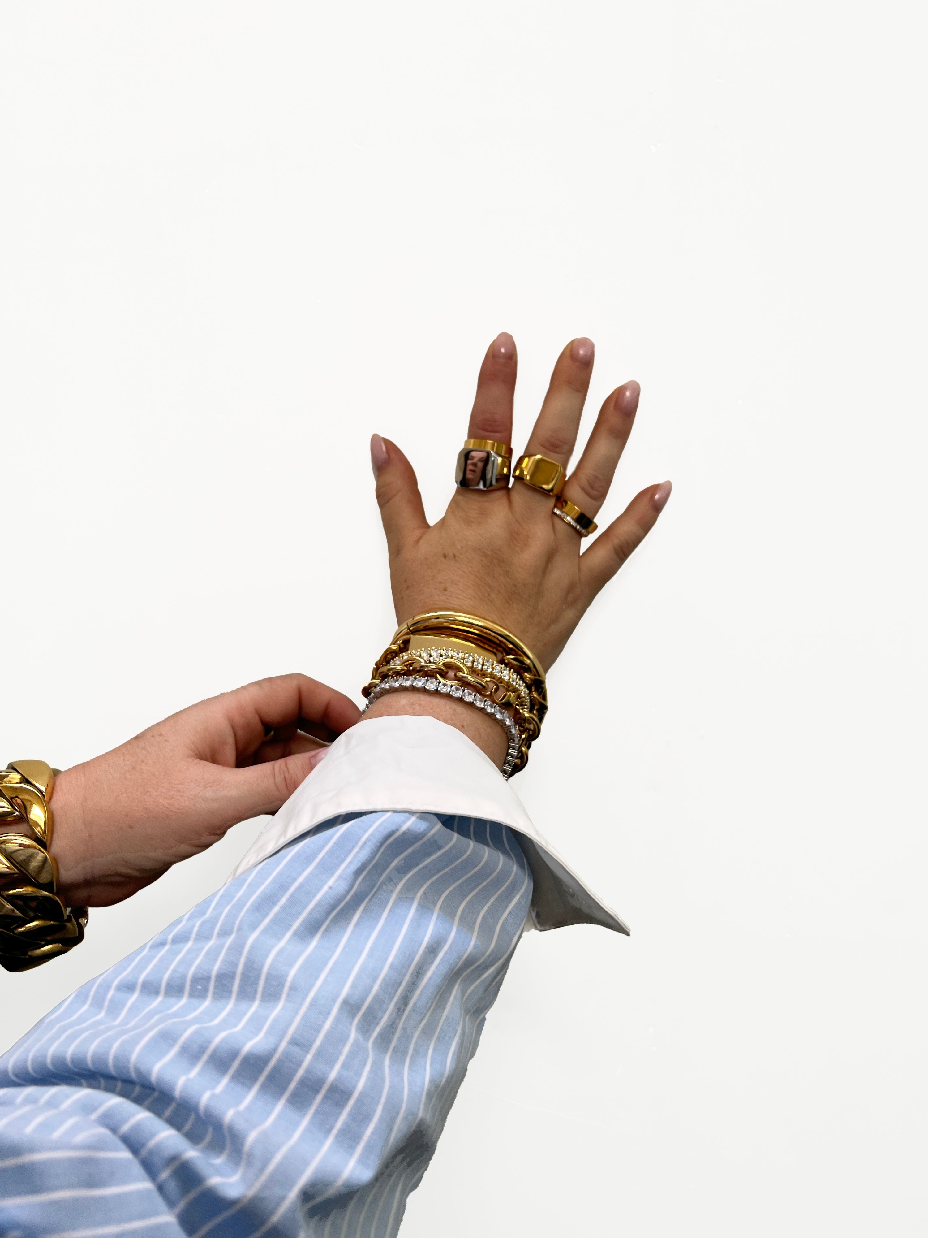 jewelry stacks on hand with bracelets and rings