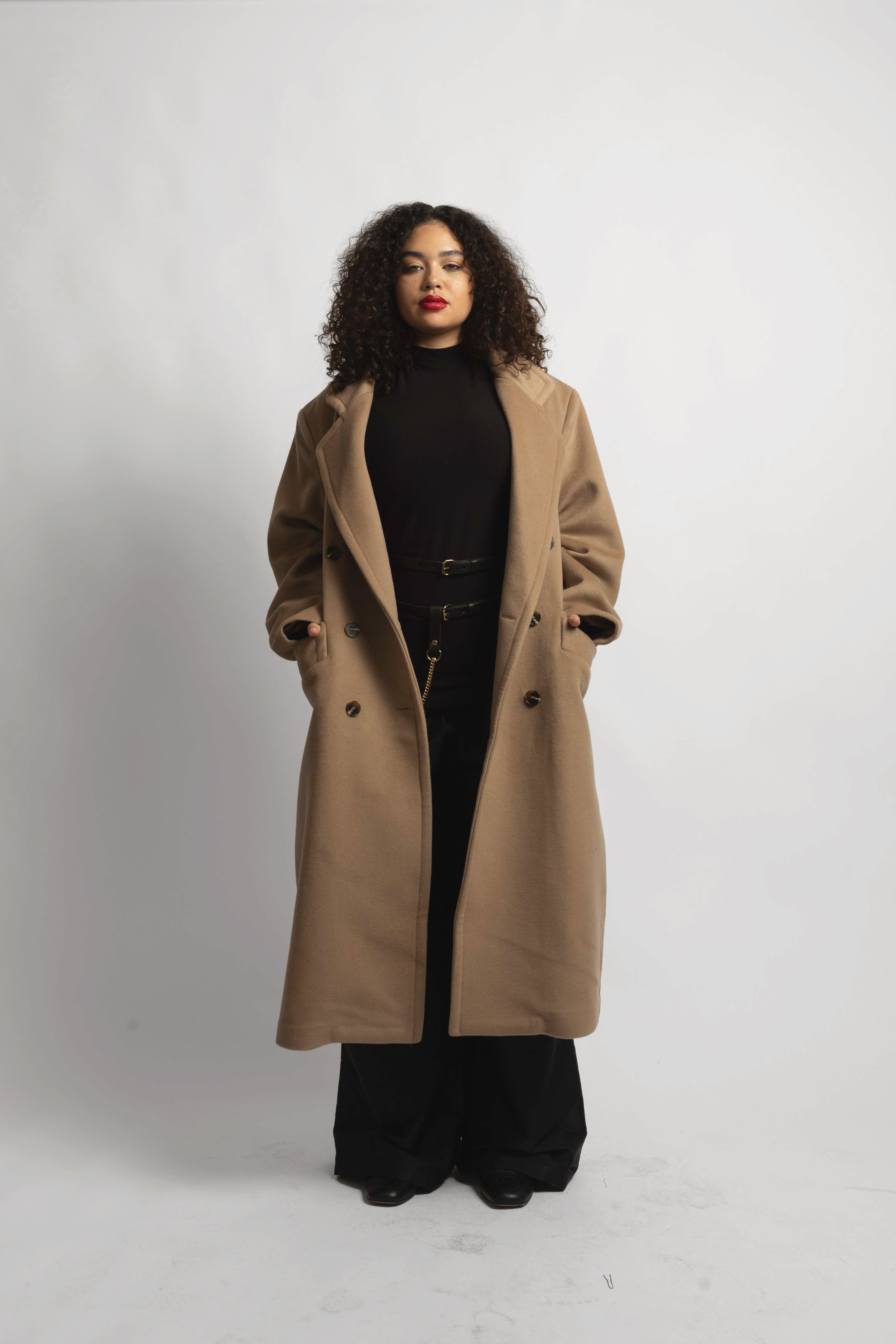 model wearing soft camel coat with hands in her pocket